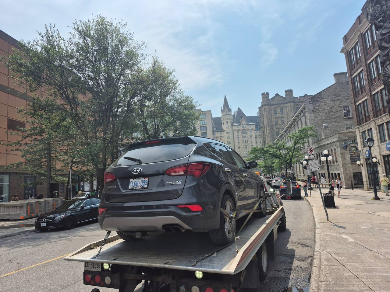 TowMania tow truck moving a Hyundai Santa Fe through downtown Ottawa near the Château Laurier